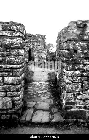 Blick durch die Überreste einer Tür zwischen alten Burgruinen in Schwarz und weiß. Die ursprüngliche Burg von Aberystwyth wurde von den Normannen in der gebaut Stockfoto