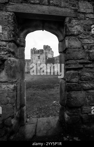 Schwarz-weiß-Blick durch eine schmale Tür im Innenhof von Chepstow Castle in Wales. Stockfoto