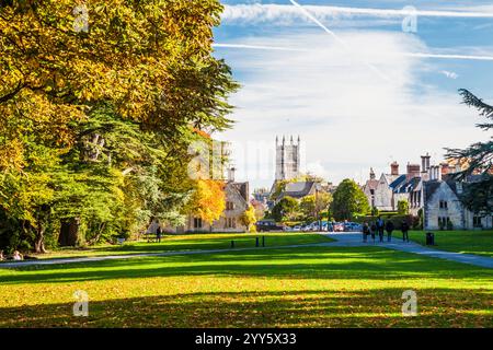 Wunderschöne Herbstfarben im Cirencester Park auf dem Bathhurst Estate in Gloucestershire. Der Turm der Kirche Johannes des Täufers. Stockfoto