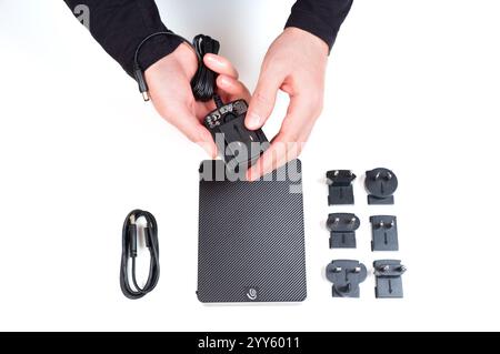 Kiew, Ukraine - 23. Oktober 2024: Hände halten den Stecker, während sie ihn mit Kabeln und Steckern an das Seagate Expansion Netzteil anschließen Stockfoto