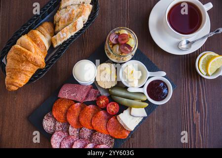 Brunch- oder Frühstücksset, verschiedene Gerichte mit gekochtem Ei, Salami, Fleisch und Käse, Müsli, Smoothie, Obst und Beeren. Serviert mit Brot und einer Stockfoto
