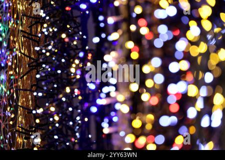 Weihnachtslichter an elektrischen Girlanden in einem Geschäft. Neujahrsdekoration in verschiedenen Farben Stockfoto