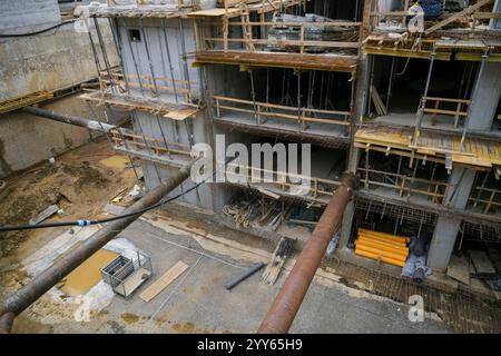 Stahlbetonuntergeschoss eines im Bau befindlichen Residentalhochhauses im neuen Stadtteil. Betongießen, Metallrahmenpfähle, Stahlstäbe Stockfoto