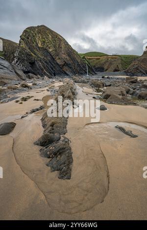 Felsen tauchten bei Ebbe bei Sandymouth North West Cornwall auf Stockfoto