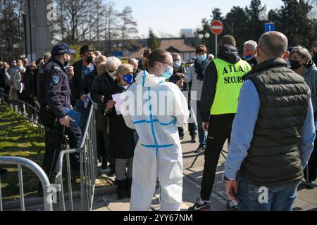 Die Menschen stehen auf der Belgrader Messe vor dem Kontrollpunkt in langen Warteschlangen, während sie auf die Impfung gegen das Coronavirus covid 19 warten. Massenimpfung. Stockfoto
