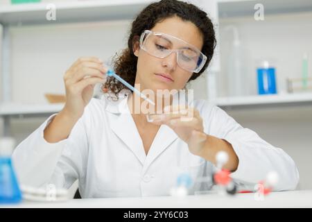 Junge Frau Techniker verwendet eine Pipette in einem chemischen Labor Stockfoto