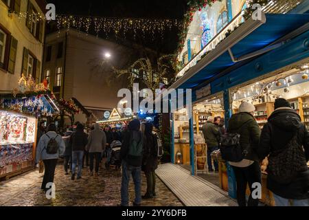 Basel, Schweiz - 5. Dezember 2024: Traditionelle Weihnachtsmarktpyramide am Abend auf dem Barfusserplatz mit festlichen Lichtern Stockfoto