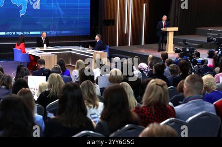 Moskau, Russland. Dezember 2024. Der russische Präsident Wladimir Putin, 2. Links, hört eine Frage zusammen mit den Gastgebern Alexandra Suworova, links, und Dmitri Kulko, 2. Rechts, und dem Sprecher des Kremls Dmitri Peskow, rechts, während der jährlichen Pressekonferenz und Call-in-Show in Gostinny Dvor, 19. Dezember 2024 in Moskau. Quelle: Vyacheslav Prokofyev/Kreml Pool/Alamy Live News Stockfoto