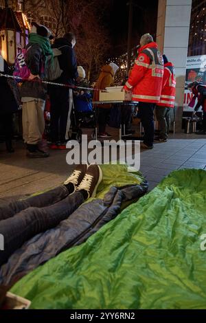 Hamburg, Deutschland. Dezember 2024. Freiwillige Mitglieder des Deutschen Roten Kreuzes (DRK) verteilen am Gerhart-Hauptmann-Platz Lebensmittel an Obdachlose. Quelle: Georg Wendt/dpa/Alamy Live News Stockfoto