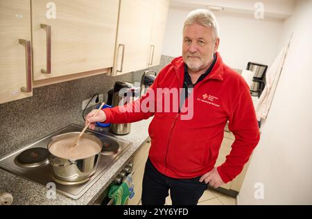 Hamburg, Deutschland. Dezember 2024. Frank Tretow, ein ehrenamtliches Mitglied des Deutschen Roten Kreuzes (DRK), bereitet Kakao zu, der später an bedürftige Menschen in der Innenstadt verteilt wird. Quelle: Georg Wendt/dpa/Alamy Live News Stockfoto