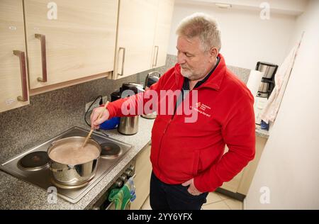 Hamburg, Deutschland. Dezember 2024. Frank Tretow, ein ehrenamtliches Mitglied des Deutschen Roten Kreuzes (DRK), bereitet Kakao zu, der später an bedürftige Menschen in der Innenstadt verteilt wird. Quelle: Georg Wendt/dpa/Alamy Live News Stockfoto