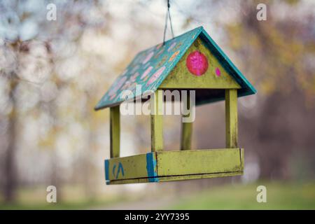 Farbenfrohes, handgefertigtes Vogelfutter (selektiver Fokus). Frühlingsblühender Garten im Hintergrund. Stockfoto