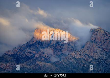 Das Sonnenlicht erleuchtet den Tafelberg in der Pusch Ridge, während nebelige Sturmwolken sich zu lösen beginnen. Tucson/Oro Valley, Arizona. Stockfoto