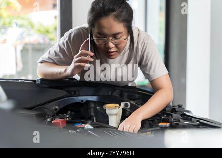 Unzufriedene junge Erwachsene Frau bricht Auto mitten auf der Fahrt auf der Straße, ruft Abschleppwagen an, um Auto zu reparieren, Pannenhilfe, Pannenpanne ca. Stockfoto