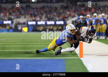 Inglewood, Kalifornien, USA. Dezember 2024. Der Denver Broncos Wide Receiver MARVIN MIMS (19) wird von den Los Angeles Chargers Cornerback KRISTIAN FULTON (7) während eines NFL-Fußballspiels zwischen den Denver Broncos und den Los Angeles Chargers im SoFi Stadium in Inglewood, Kalifornien, aus dem Spiel geholt. (Kreditbild: © Brenton TSE/ZUMA Press Wire) NUR REDAKTIONELLE VERWENDUNG! Nicht für kommerzielle ZWECKE! Stockfoto