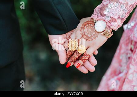 Eine Nahaufnahme der Hände einer frisch verheirateten Braut und eines Bräutigams aus der Hinduhochzeit, romantisches Hochzeitskonzept der Liebe Stockfoto