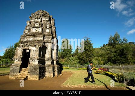 Ein Mann, der vom Bima-Tempel, einem alten Hindu-Tempel auf dem Dieng-Hochplateau, der administrativ in Dieng Kulon, Batur, Banjarnegara, Zentral-Java, Indonesien liegt, entfernt ist. Stockfoto