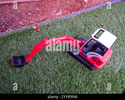 Spielzeug-Baggerlader auf dem Gras im Hinterhof Stockfoto