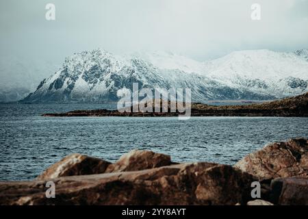 Schneebedeckte Berge mit Blick auf die felsige Küste Stockfoto