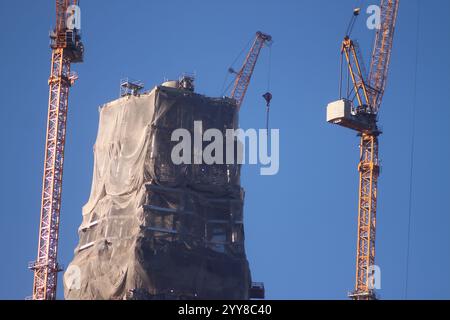 Ein großes Gebäude mit Kränen im Hintergrund wird gebaut Stockfoto