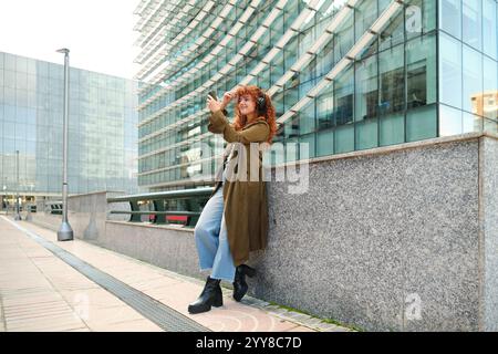 Frau, die Selfie mit dem Telefon macht und Musik in der Stadt hört Stockfoto
