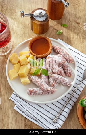 Italienische Würstchen und Käse auf einem Teller. Snacks für Wein Stockfoto