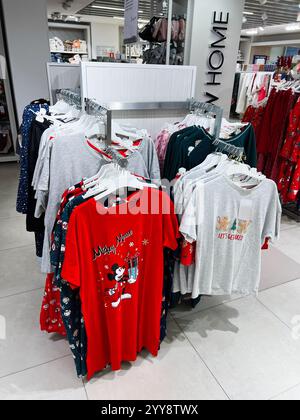Kiew, Ukraine - 18. Dezember 2024: Ein Regal mit T-Shirts mit festlichen Motiven, die in einem Einzelhandel ausgestellt werden. Das Bild vermittelt ein festliches Bild Stockfoto