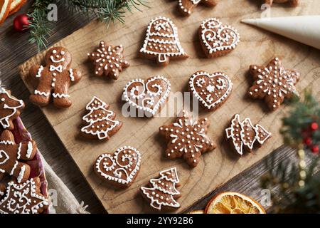 Hausgemachte Lebkuchenweihnachtskekse mit weißer Glasur auf einem Holztisch dekorieren Stockfoto