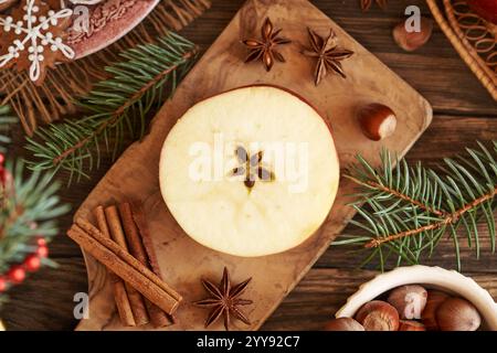 Ein halber Apfel mit einem Stern in der Mitte mit Zimt, Sternanis und Lebkuchen Weihnachtskekse Stockfoto