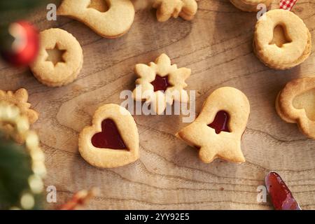 Glocken-, Stern- und herzförmige selbstgemachte Linzer Weihnachtskekse gefüllt mit Erdbeermarmelade, Blick von oben Stockfoto