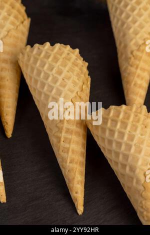 Leere Waffelkegel für Eis auf einem schwarzen Schiefer, mehrere Waffelkegel für Eis Stockfoto