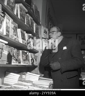 Buchhandlung in den 1940er Jahren Ein Mann steht verwirrt vor den Regalen der Detektivromane. Unter ihnen ist Weyler Hildebrands Gentleman Gangster. Andere Bücher in den Regalen haben auffällige Titel wie: Mit unverschmückten Lippen, der grüne Geist, der Mann mit der Ebermaske, der Mord im Parkhotel. 1947. Kristoffersson Ref. AA29-10 Stockfoto