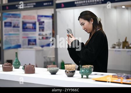 Haikou, chinesische Provinz Hainan. Dezember 2024. Ein Besucher macht Fotos auf der Hainan International Intellectual Property Trade Conference in Haikou, südchinesischer Provinz Hainan, 20. Dezember 2024. Die Konferenz begann am Freitag hier. Quelle: Pu Xiaoxu/Xinhua/Alamy Live News Stockfoto