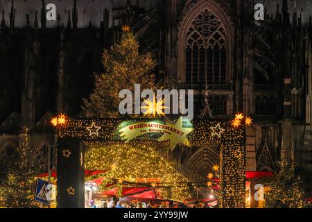 Weihnachten 2024 in Köln. Eingang zum Weihnachtsmarkt am Dom zu Köln bei Nacht. Im Hintergrund ist ein Ausschnitt der Fassade des Kölner Domes zu sehen. Köln Nordrhein-Westfalen Deutschland *** Weihnachten 2024 in Köln Eingang zum Weihnachtsmarkt am Kölner Dom bei Nacht ist Ein Abschnitt der Fassade des Kölner Doms im Hintergrund Köln Nordrhein-Westfalen zu sehen Stockfoto