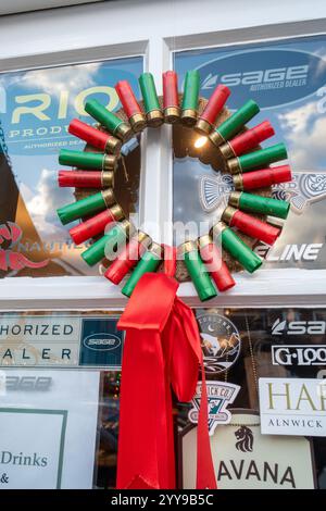 Schrulliger Weihnachtskranz aus Schrotflintenpatronen hängt an der Tür eines Angel- und Schießgeschäfts in Stockbridge, Hampshire, England, Großbritannien Stockfoto