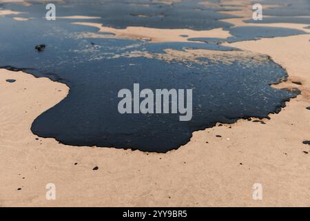 Heizöl an der Seeküste nach einem Tankerunglück. Der Strand ist mit Öl verschmutzt Stockfoto