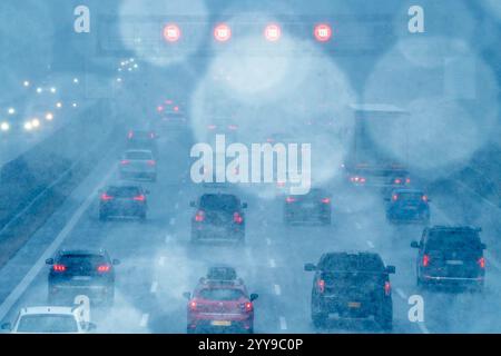 Schneetreiben und dichter Weihnachts-Reiseverkehr auf der Autobahn A8, München-Salzburg, in Richtung Süden, Wintereinbruch, Sauerlach, 20. Dezember 2024 Deutschland, Sauerlach bei München, 20. Dezember 2024, Schneetreiben und dichter Weihnachts-Reiseverkehr auf der Autobahn A8, München-Salzburg, in Richtung Süden, Start in die Weihnachtferien, volle Autobahn am Freitagnachmittag um 15 Uhr, Wintereinbruch, Temperatur ca. 1 Grad Celsius, kalt, Kälte, Schilderbrücke zeigt Tempolimit 120, trotz Schneetreiben, Verkehr am frühen Nachmittag, kurz vor Weihnachten, Winter, Winterwetter, Bayern *** Driv Stockfoto