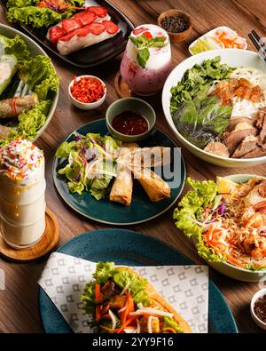 Ein farbenfrohes vietnamesisches Festmahl mit frischen Frühlingsrollen, knusprigen Eierrollen, Nudelschüsseln, Banh mi Sandwiches und lebhaften Getränken – Stockfoto