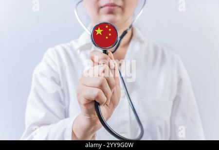 Ärztin, die ein Stethoskop mit China-Flagge hält. Nationales Gesundheitssystem Chinas Stockfoto