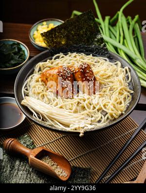 Traditionelle japanische Ramen werden in einer reichhaltigen Brühe mit weich gekochten Eiern, Algen und Ramen-Nudeln serviert. Umgeben von klassischen Belägen wie Mais Stockfoto