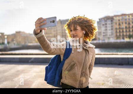 Schönheit latin junge Frau, die Selfie mit Smartphone macht und den Sonnenuntergang in der Stadt genießt Stockfoto