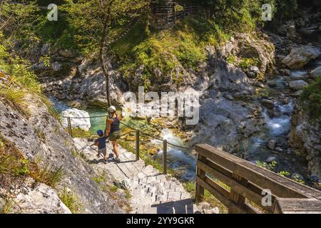 Mutter und Kind steigen die Steintreppen entlang der tolmin-Schlucht in slowenien hinab und genießen den Sommertag bei der Erkundung der Natur Stockfoto