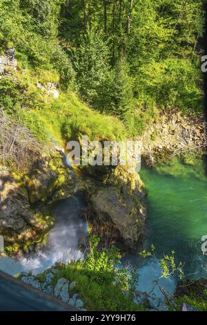 Atemberaubender Regenbogen, der sich über dem Wasserfall in türkisfarbenes Wasser in der vintgar-Schlucht in der Nähe von Bled, slowenien, bildet, einem beliebten Touristenziel Stockfoto