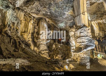 Touristen bewundern riesige Stalaktiten und Stalagmiten in der berühmten Höhle von postojna, eine der wichtigsten Touristenattraktionen in slowenien Stockfoto