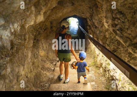 Mutter und Sohn gehen die Treppe hinauf in einem Tunnel, der in die Felswände der tolmin-Schlucht in slowenien gehauen ist Stockfoto