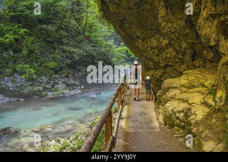 Touristen, die entlang des Flusses radovna in der vintgar-Schlucht in der Nähe von Bled in slowenien spazieren, genießen die atemberaubende Landschaft und die friedliche Umgebung Stockfoto