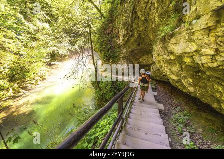 Touristen mit Helmen gehen die Holztreppen entlang des Flusses radovna in der Schlucht vintgar hinunter, ein beliebtes Touristenziel in der Nähe von Bled, slowenien Stockfoto