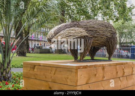 Wicker Art Installation eines Dachses auf einer hölzernen Plattform umgeben von Bäumen in einem Park, London, England, 20. Juli 2023 Stockfoto