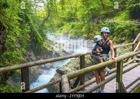 Mutter mit ihrem Kind beim Besuch der atemberaubenden vintgar-Schlucht in der Nähe von Bled, slowenien, mit atemberaubendem Blick auf den türkisfarbenen Fluss und die üppige Landschaft Stockfoto