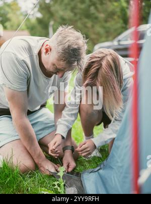 Vater und Tochter richteten während des Sommerurlaubs der Familie Ein Zelt auf Einem Campingplatz auf Stockfoto